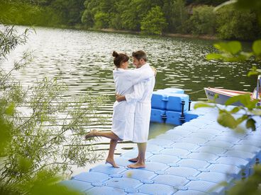 Verliebtes Paar steht im Bademantel auf dem Badesteg am Diemelsee.