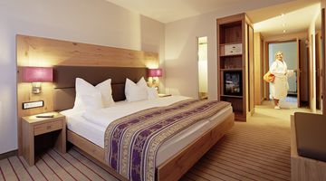 Deluxe-Doppelzimmer im Gartenflügel mit gemütlichem Bett, Sessel und Couch  