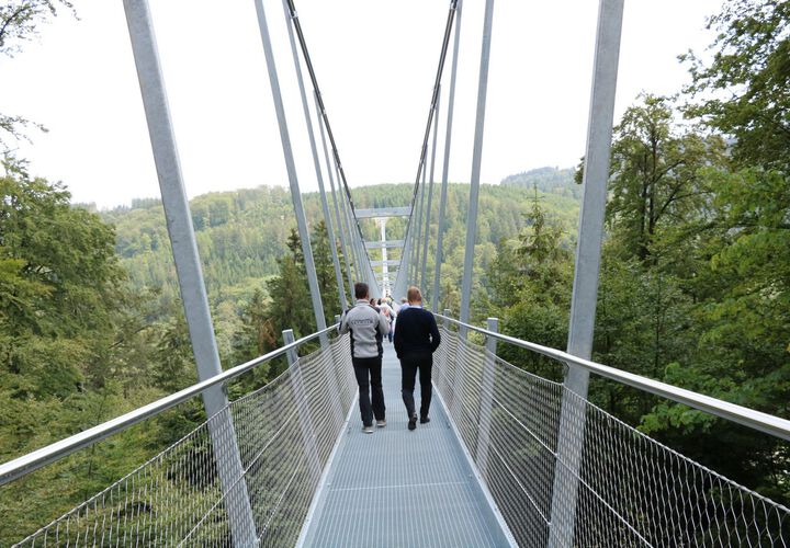 Personen laufen über die lange Hängebrücke 