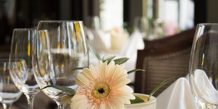 Weingläser und Blumen auf einem gedeckten Tisch 