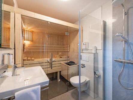 Modernes Badezimmer mit integrierter Sauna und Glasdusche