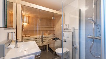 Modernes Badezimmer mit integrierter Sauna und Glasdusche