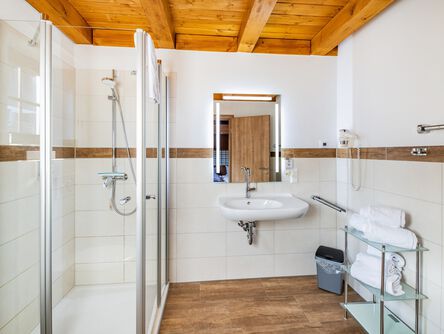 Helles Badezimmer mit Glasdusche und Holzdecke