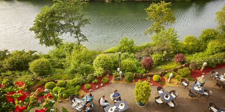 Terrassenrestaurant mit Blick auf einen Fluss und grüne Natur