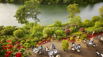 Terrassenrestaurant mit Blick auf einen Fluss und grüne Natur