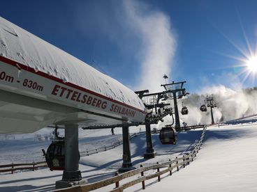 Ettelsberg Seilbahn an einem verschneiten Hang bei Sonnenschein