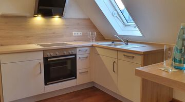 Weiße Küche mit Arbeitsfläche aus hellem Holz