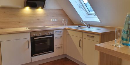 Weiße Küche mit Arbeitsfläche aus hellem Holz