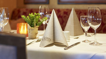 Gefaltete Göbels Serviette auf einem gedeckten Tisch im Restaurant 