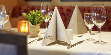 Gefaltete Göbels Serviette auf einem gedeckten Tisch im Restaurant 