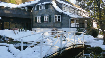 Eingeschneite Brücke über einem Bach 