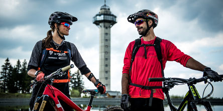 Paar mit Mountainbikes vor dem Ettelsbergturm schauen sich an 