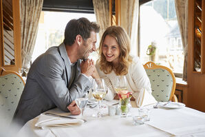 Lachendes Paar hält Händchen und sitzt an einem Tisch in einem Restaurant 