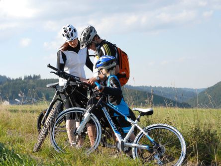 Familie blickt bei ihrer Fahrradtour auf einer Karte