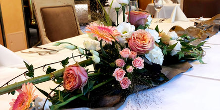 Tisch dekoriert mit einem großen Blumengesteck 