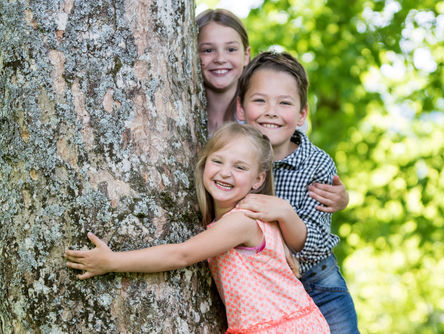 Kinder umarmen einen Baum