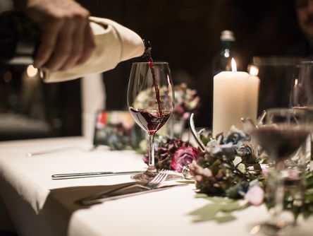 Rotwein wird in ein Glas eingegossen