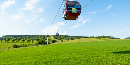 Kabinenbahn zum Ettelsberg über einer grünen Wiese