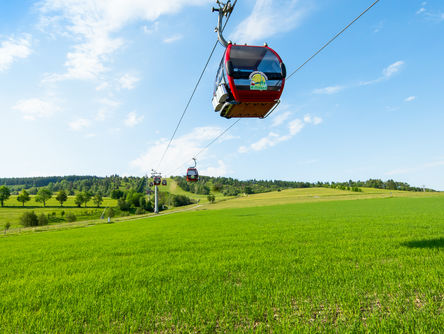 Kabinenbahn zum Ettelsberg über einer grünen Wiese