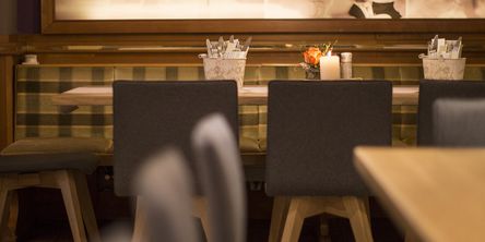 Blick auf einen Tisch im Restaurant  an einer grün karierten Sitzbank 