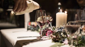 Rotwein wird in ein Glas eingegossen