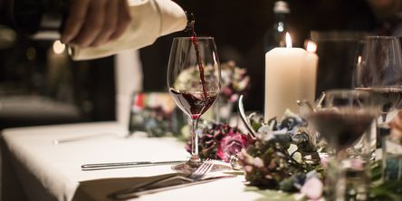 Rotwein wird in ein Glas eingegossen