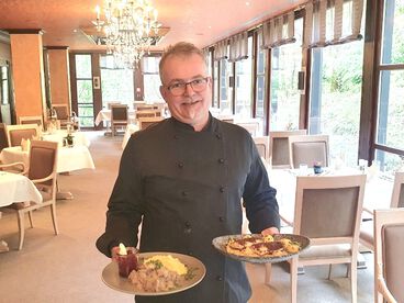 Küchenchef Thomas Fritz drapiert ein Gericht auf einer Schieferplatte