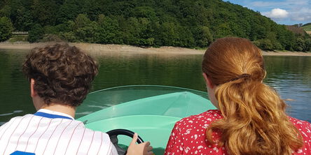 Zwei Personen fahren zusammen in einem Boot über dem See