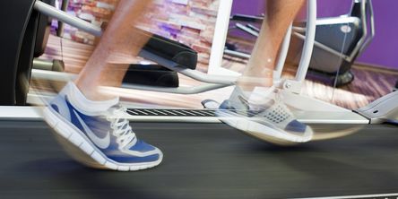 Nahaufnahme der Beine mit Sportschuhen eines Sportlers auf dem Laufband