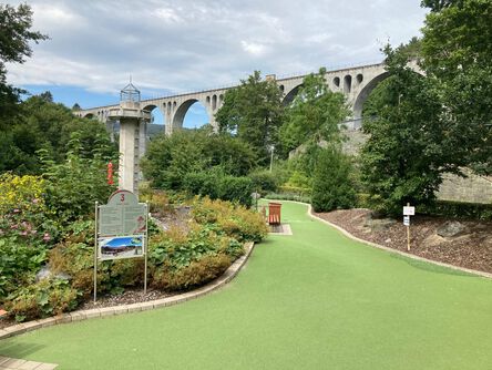 Park neben einer Brücke mit hohen Bögen 