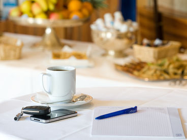 Nahaufnahme einer Kaffeetasse, Stift, Mappe, Smartphone und Autoschlüssel auf einem Tisch