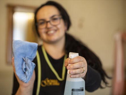 Hausdame hält eine Sprühflasche in der Hand