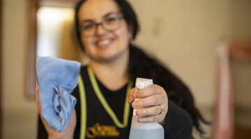 Hausdame hält eine Sprühflasche in der Hand