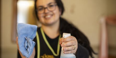 Hausdame hält eine Sprühflasche in der Hand