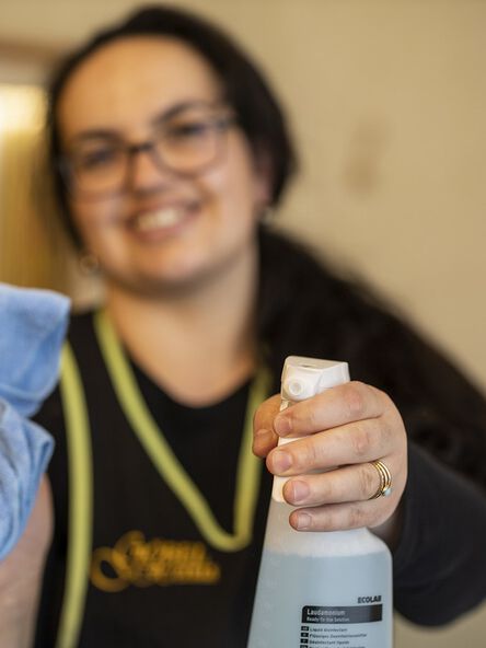 Hausdame hält eine Sprühflasche in der Hand