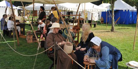 Frauen beim Körbe flechten und Männer im Handwerk auf einem historischen Markt