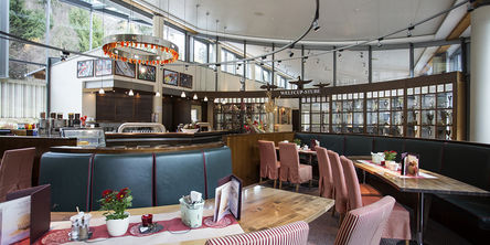 Einblick in das Restaurant mit Tisch an großen geschwungenen Ledersitzbänken