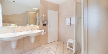 Helles Badezimmer mit zwei Waschbecken an einen großen Spiegel im Appartement 