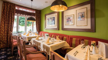 Gedeckte Tische und Sitzecke im Parkrestaurant