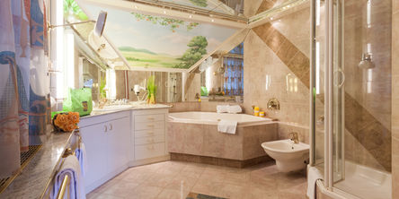 Einblick in das geräumige Badezimmer mit einer Eckbadewanne, Dusche und Bidet 