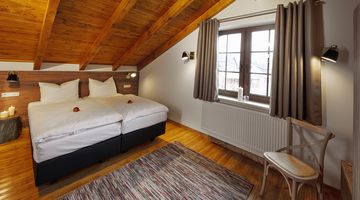 Schlafzimmer mit Doppeltbett und hölzerner Decke in der Premium-Chalet Ferienwohnung am Diemelsee.