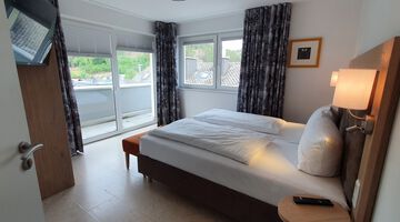 Schlafzimmer im Almloft mit Doppelbett und Zugang zum Balkon 