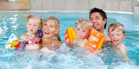 Eltern mit ihren Kindern im Pool 