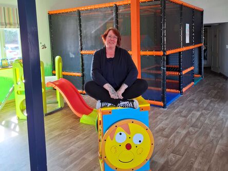 Steffi, die Leitung des Sharkie Island Abenteuerspielplatzes sitzt auf einer Spielkiste.