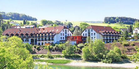 Außenansicht auf Göbel's Seehotel Diemelsee und die umliegende grüne Landschaft.