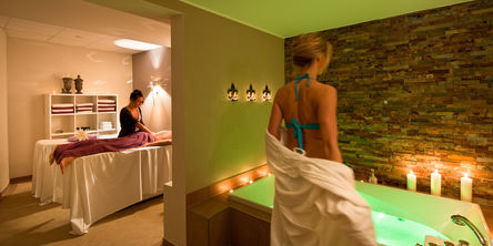 Eine Frau bereitet sich vor, die befüllte Badewanne im Wellnesshotel am Diemelsee zu betreten.