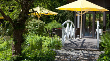 [Translate to english:] Eine Brücke im Garten des Hotels Stryckhaus führt über den Teich.