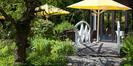 [Translate to english:] Eine Brücke im Garten des Hotels Stryckhaus führt über den Teich.