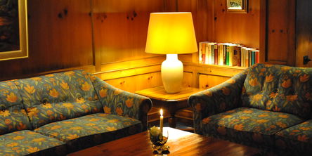 Zwei Sofas mit Blumenmuster an einem Holztisch mit brennender Kerze