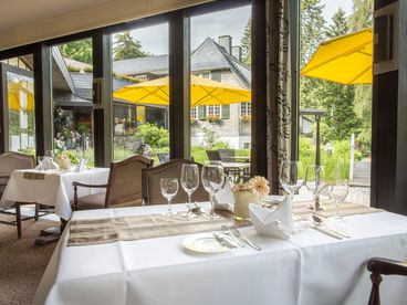 Gedeckter Tisch am Fenster mit Blick auf den Außenbereich 